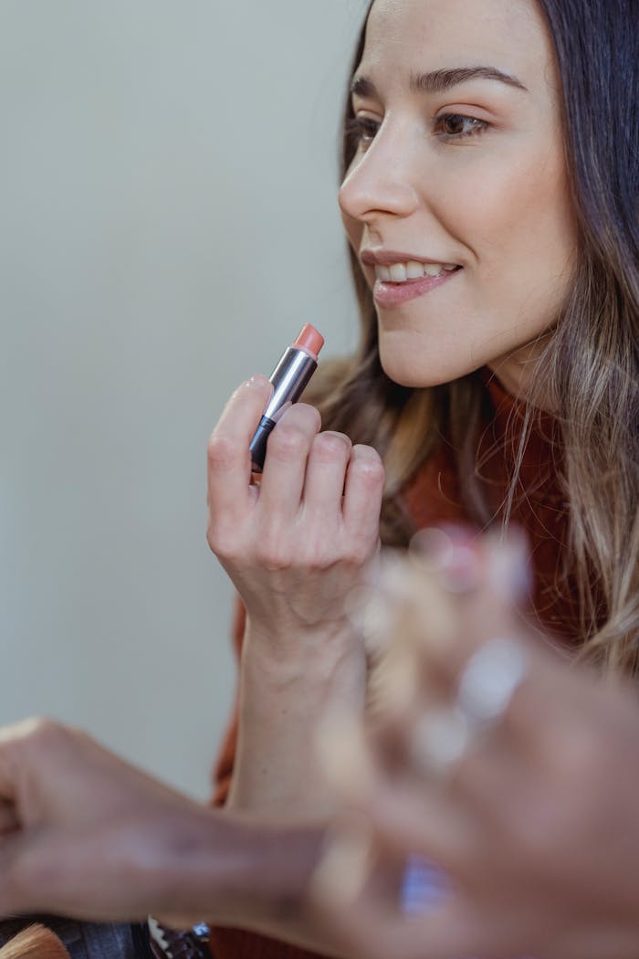 Crop cheerful female with lipstick smiling near crop anonymous African American friend on white background